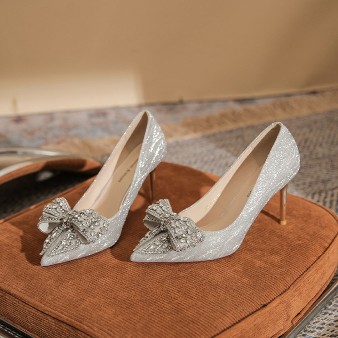 Shehzadi silver shimmer bridal stiletto heels with diamond bow - front view