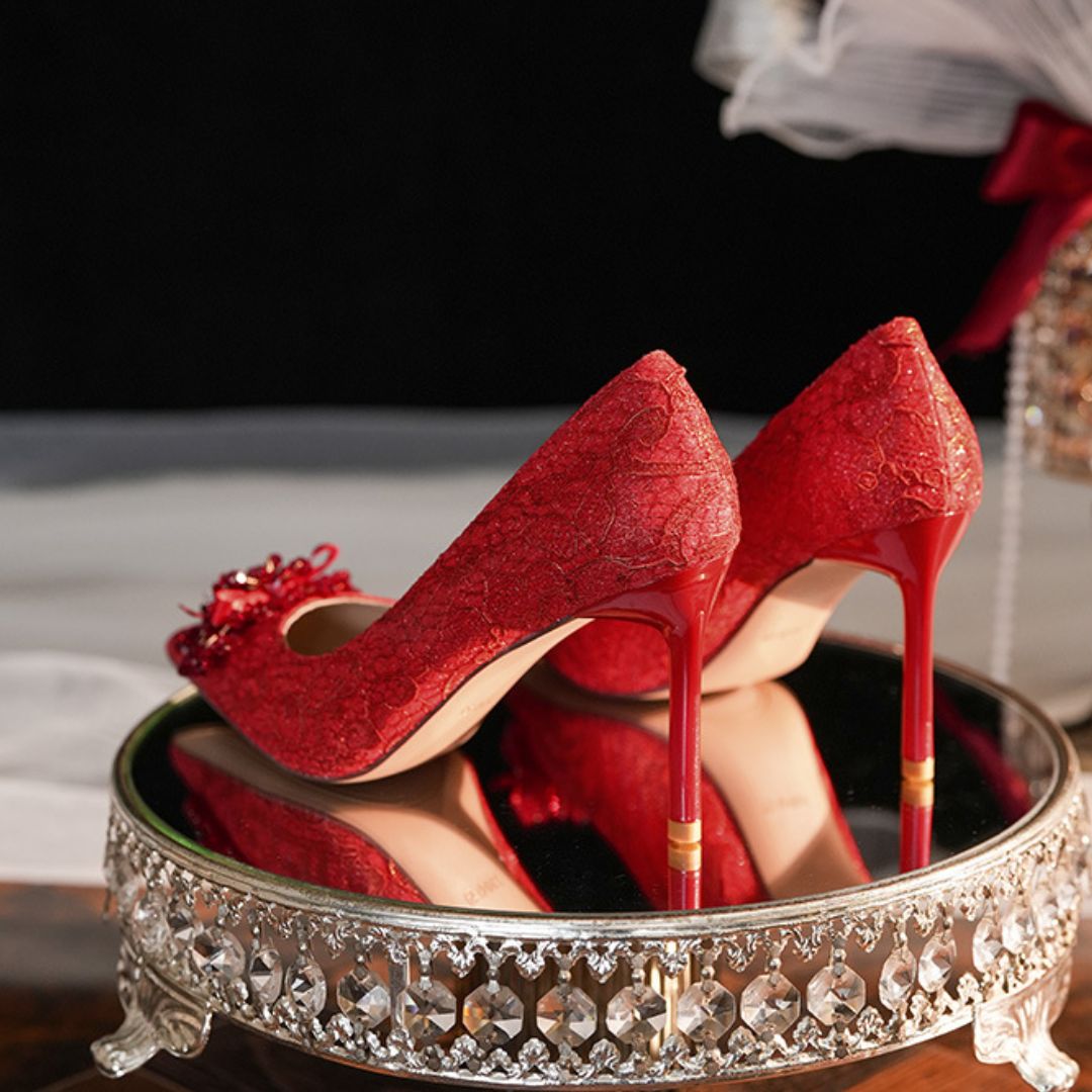 Red high-heeled shoes on a decorative stand with a blurred background