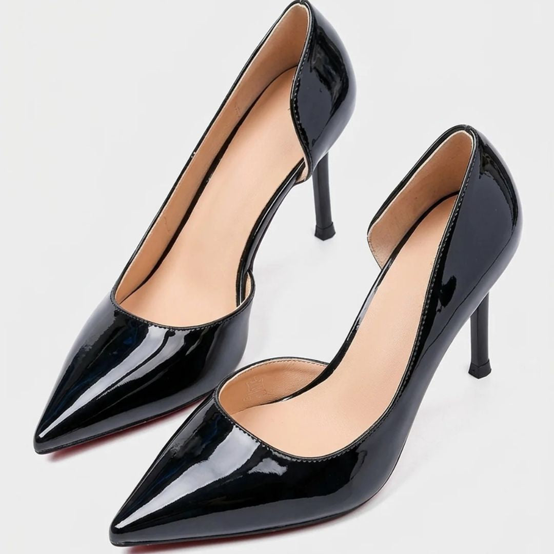 Black patent high-heeled shoes on a light gray background