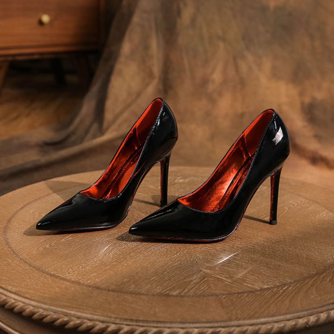 Black high-heeled shoes on a wooden surface with a blurred background