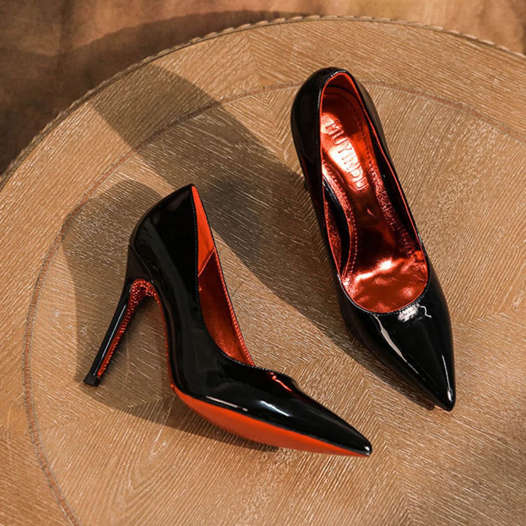 Black and red high-heeled shoes on a wooden surface